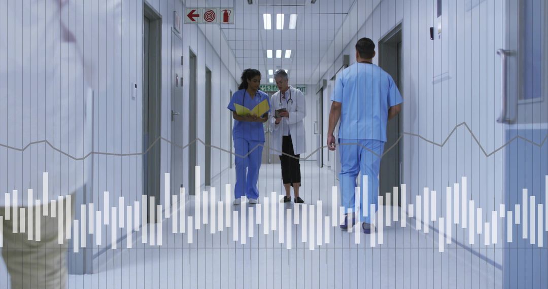 Medical team walking and discussing patient data in hospital corridor with tablet