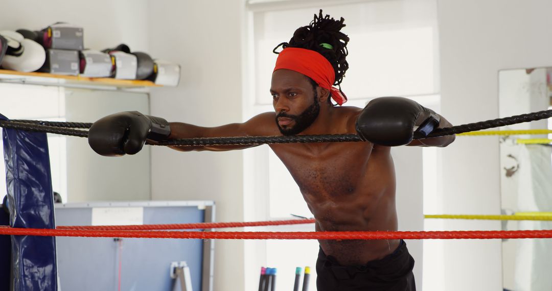 Determined Male Boxer in Boxing Ring Resting Between Rounds