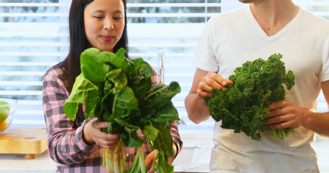 Diverse Couple Cooking with Fresh Greens in Kitchen