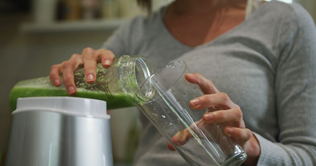 Woman Making Green Smoothie in Kitchen - Free Images, Stock Photos and Pictures on Pikwizard.com