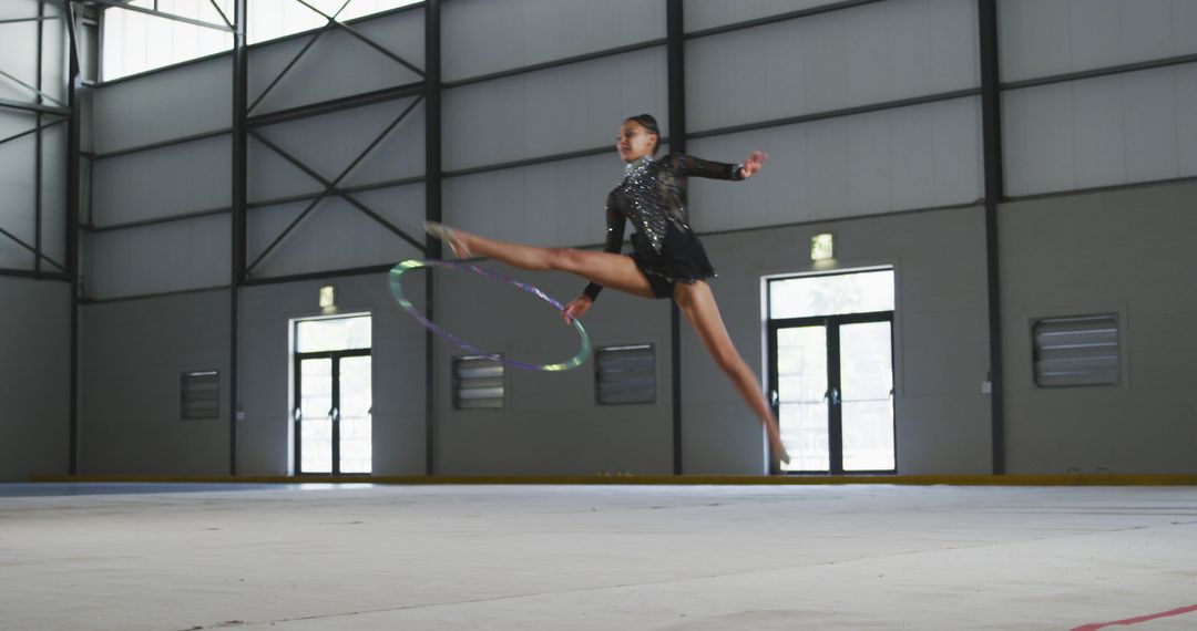 Female Rhythmic Gymnast Performing with Hoop In Large Sports Facility - Free Images, Stock Photos and Pictures on Pikwizard.com