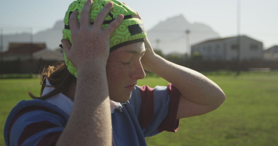 Youth Rugby Player Adjusting Helmet on Field - Free Images, Stock Photos and Pictures on Pikwizard.com