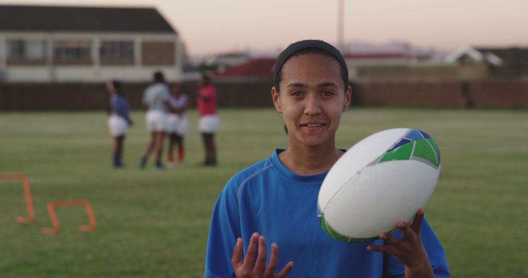 Female Rugby Player Holding Ball During Practice at Sunset - Free Images, Stock Photos and Pictures on Pikwizard.com