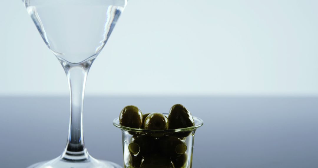 Martini Glass with Olives in Glass Jar on Minimalist Background - Free Images, Stock Photos and Pictures on Pikwizard.com