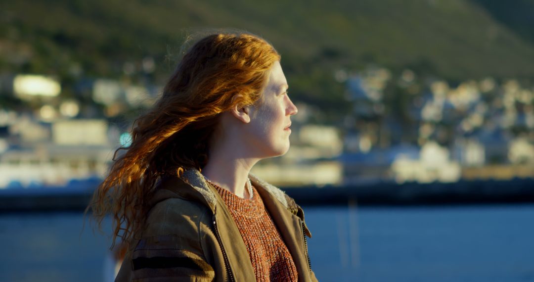 Woman with Red Hair Enjoying Scenic Waterfront View - Free Images, Stock Photos and Pictures on Pikwizard.com