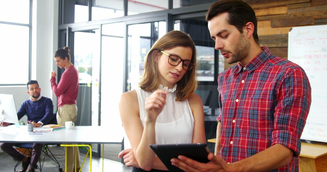 Colleagues Collaborating at Workspace with Digital Tablet Focus
