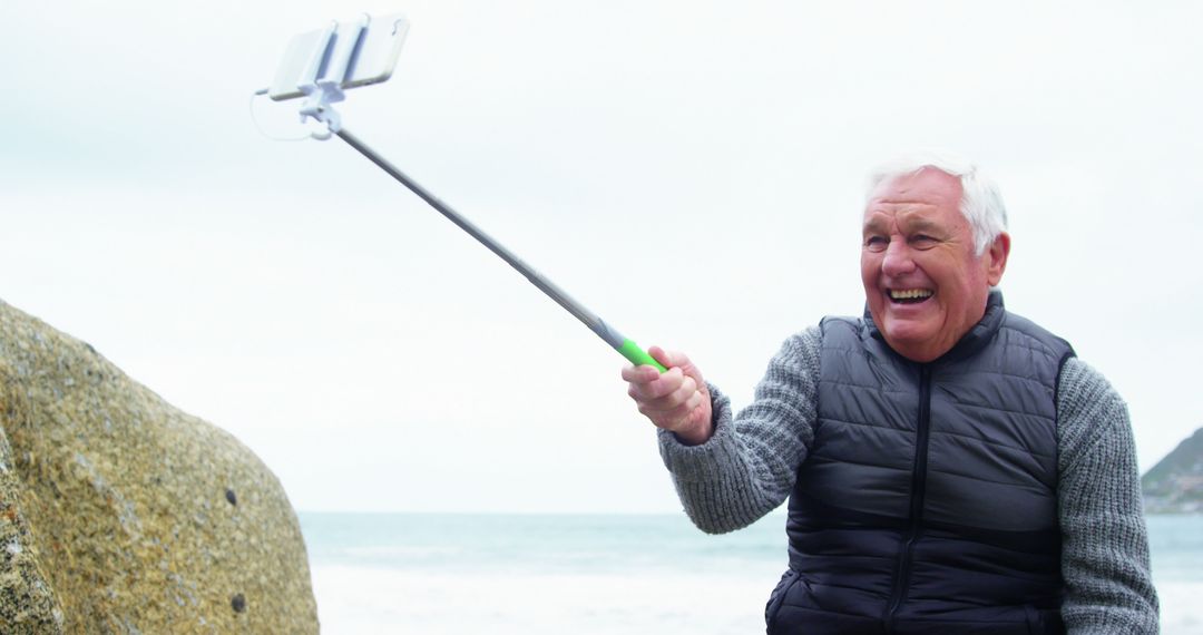 Happy Senior Man Taking Selfie by the Sea with Selfie Stick - Free Images, Stock Photos and Pictures on Pikwizard.com