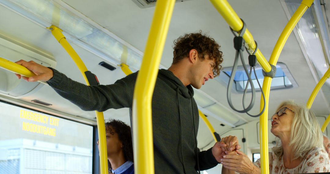 Young Man Helping Elderly Woman Stand on Bus - Free Images, Stock Photos and Pictures on Pikwizard.com