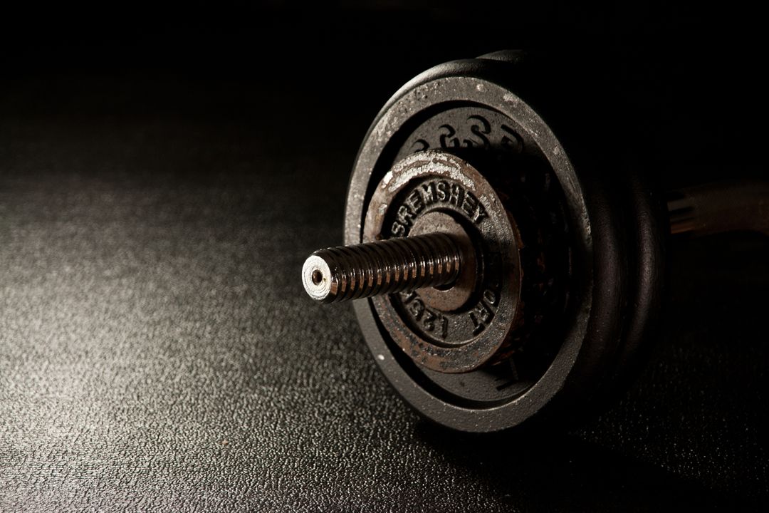 Close-Up of Dumbbell Plate on Floor with Dark Dramatic Lighting - Free Images, Stock Photos and Pictures on Pikwizard.com