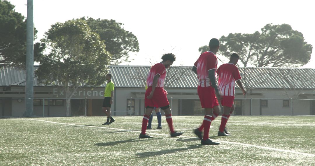 Soccer Players Practicing in Red Uniforms on Sunny Day