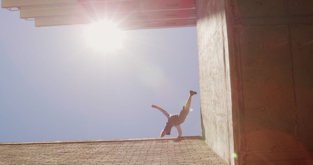 Urban Freerunner Performing Wall Flip Against Sunlit Sky - Free Images, Stock Photos and Pictures on Pikwizard.com