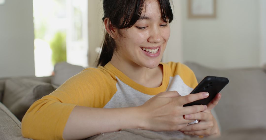 Smiling Woman Enjoying Smartphone Relaxation at Home