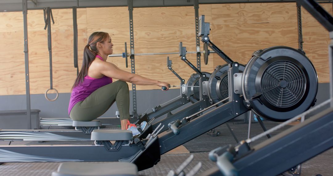 Woman Exercising on Rowing Machine in Gym for Cardio Workout - Free Images, Stock Photos and Pictures on Pikwizard.com