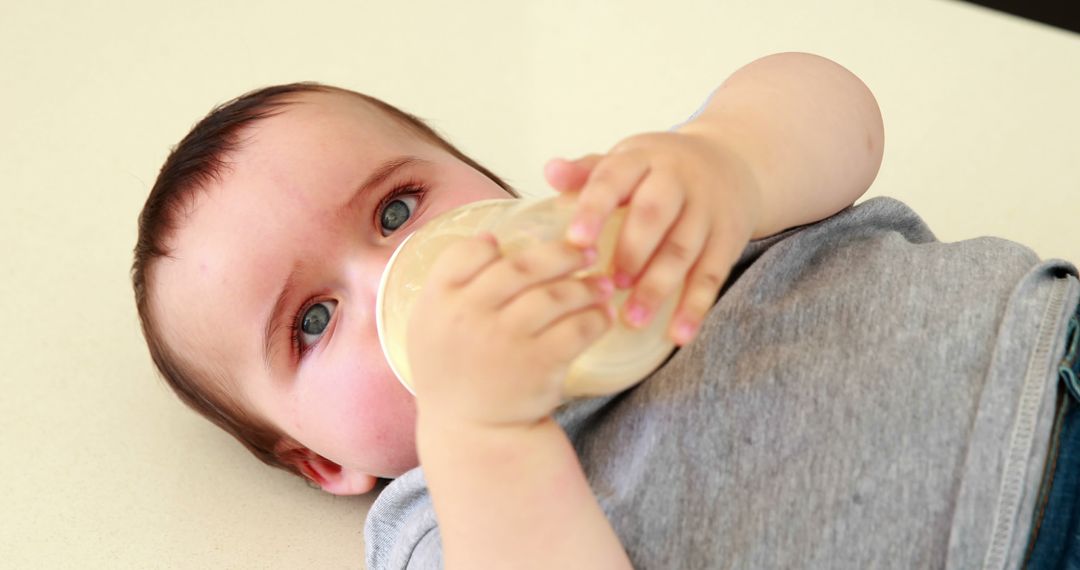 Adorable Baby with Blue Eyes Drinking Milk from Bottle - Free Images, Stock Photos and Pictures on Pikwizard.com