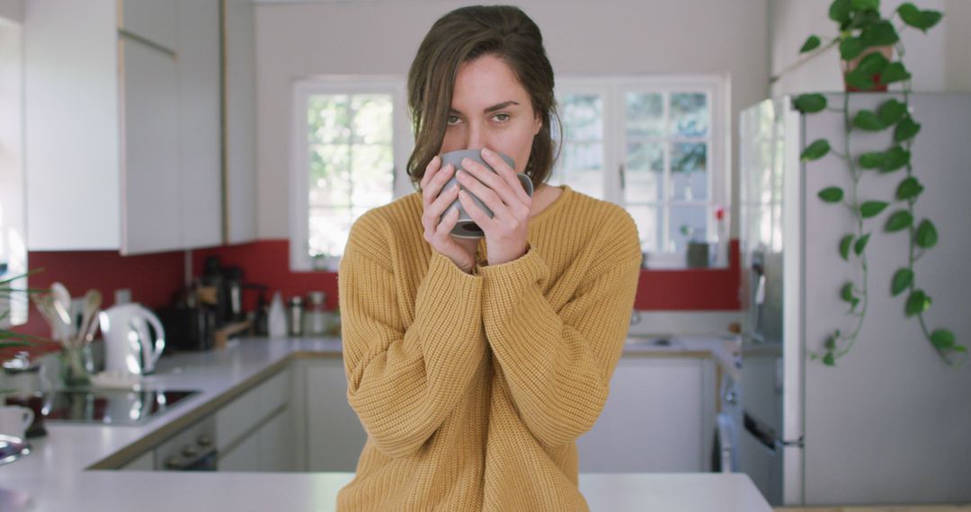 Portrait of caucasian woman drinking coffe in kitchen - Free Images, Stock Photos and Pictures on Pikwizard.com