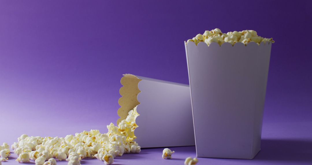 Fresh Popcorn Overflowing from White Paper Tubs on Purple Background - Free Images, Stock Photos and Pictures on Pikwizard.com