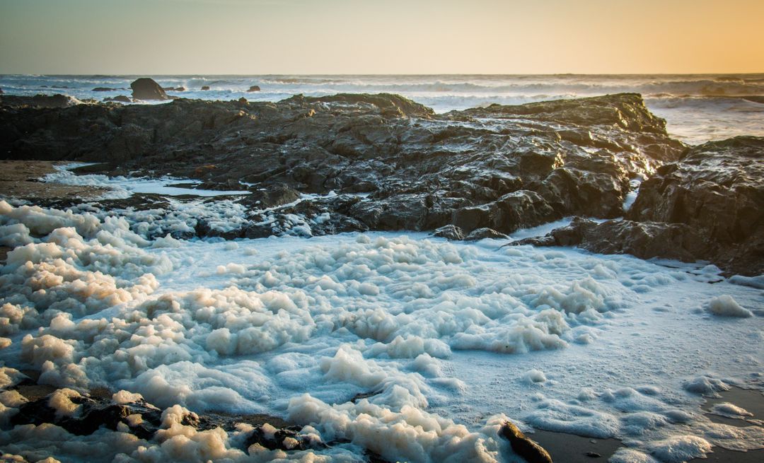 Foamy Ocean Waves Crashing Against Rocky Shoreline at Sunset - Free Images, Stock Photos and Pictures on Pikwizard.com