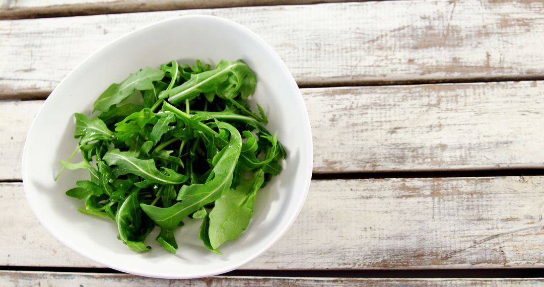 Fresh Green Arugula Leaves in White Bowl on Rustic Wooden Table - Free Images, Stock Photos and Pictures on Pikwizard.com