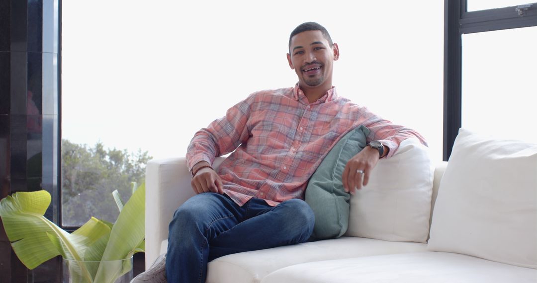 Smiling Hispanic Man Relaxing on Comfortable Sofa at Home