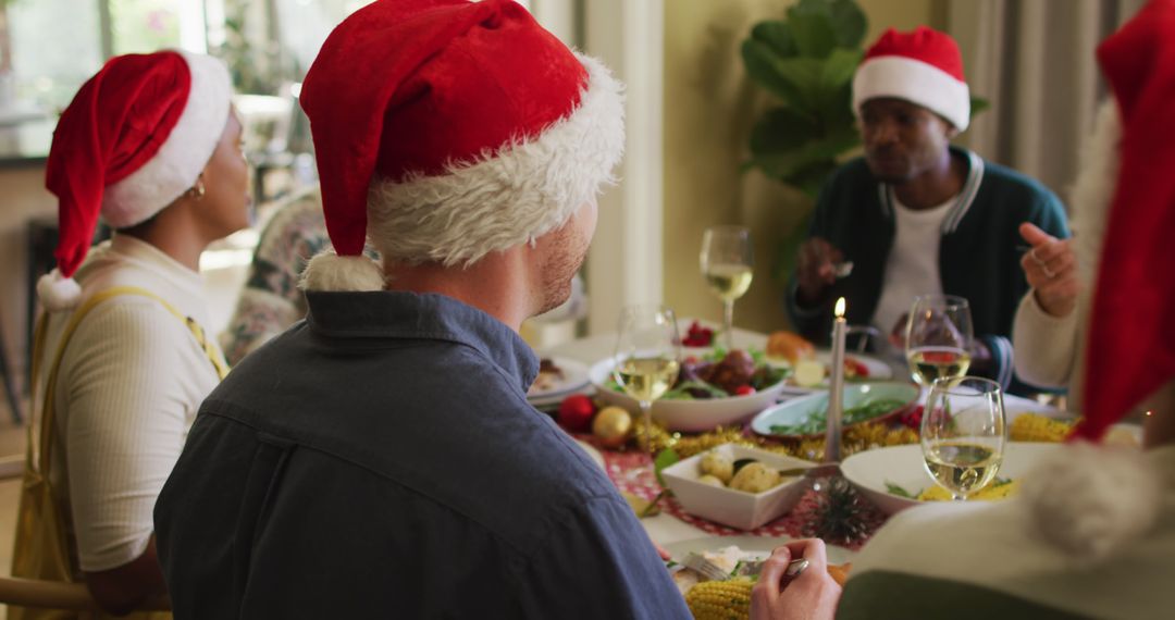 Diverse Group Enjoying Festive Christmas Dinner with Santa Hats - Free Images, Stock Photos and Pictures on Pikwizard.com