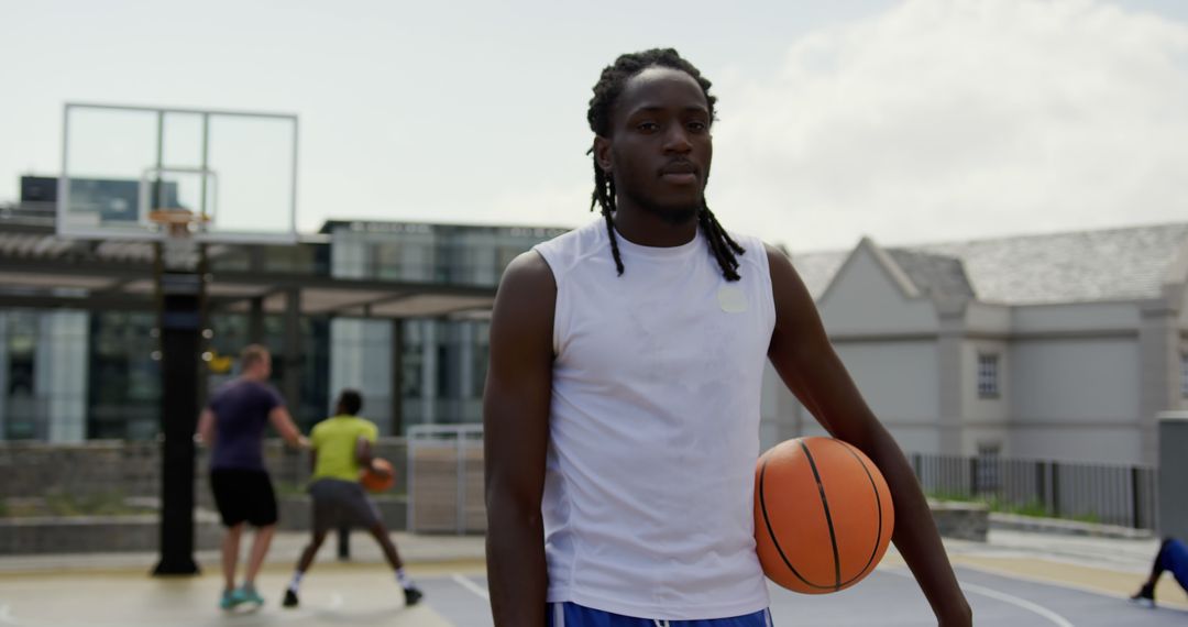 Young Man Holding Basketball on Outdoor Court - Free Images, Stock Photos and Pictures on Pikwizard.com