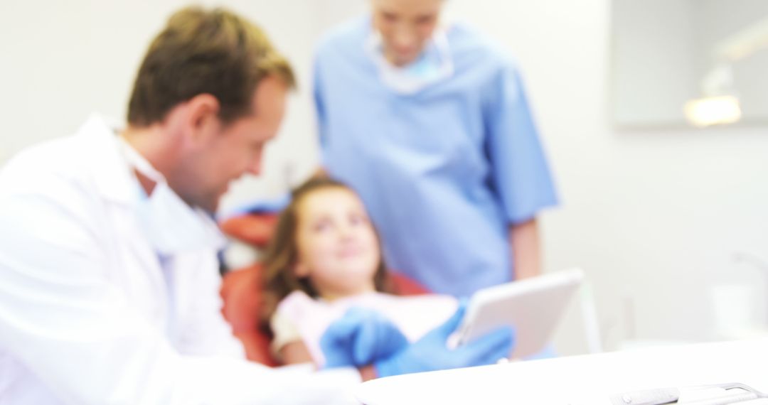 Pediatric Dentist Showing Digital Tablet to Child Patient - Free Images, Stock Photos and Pictures on Pikwizard.com