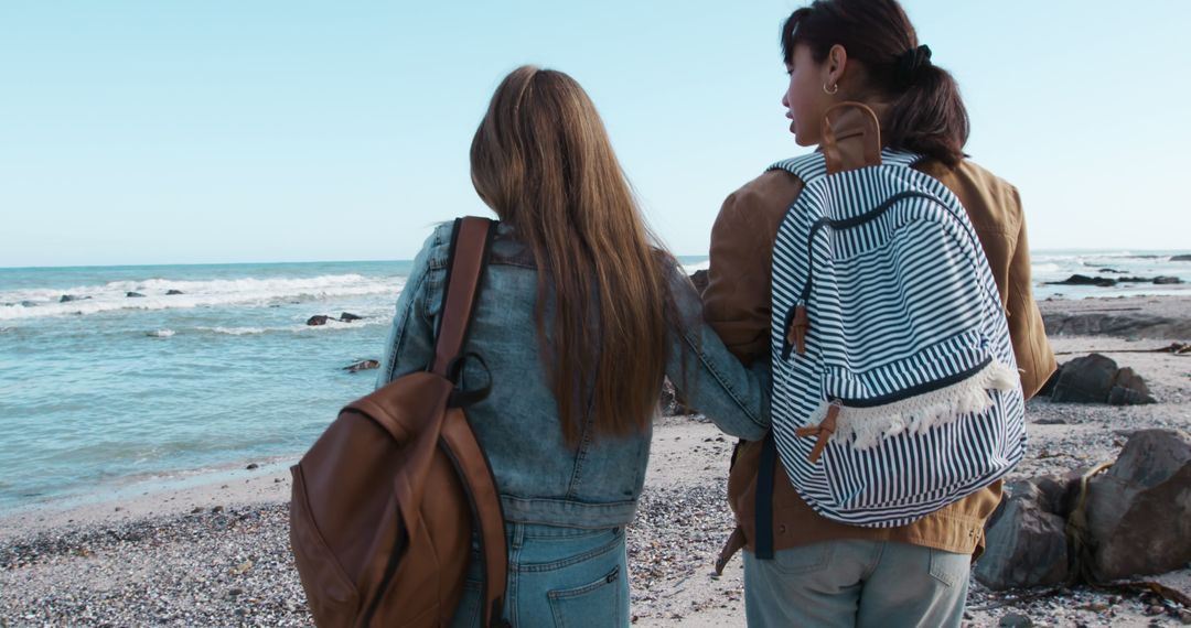 Friends Relaxing by Ocean with Backpacks on Cozy Day - Free Images, Stock Photos and Pictures on Pikwizard.com