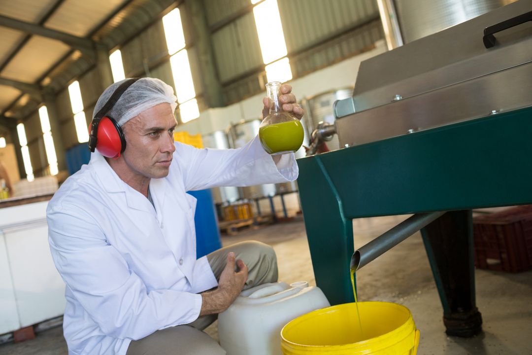 Technician Examining Olive Oil in Factory - Free Images, Stock Photos and Pictures on Pikwizard.com