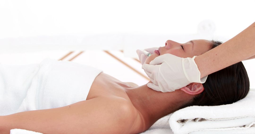 A young Caucasian woman is receiving a facial treatment from a beautician, with copy space - Free Images, Stock Photos and Pictures on Pikwizard.com