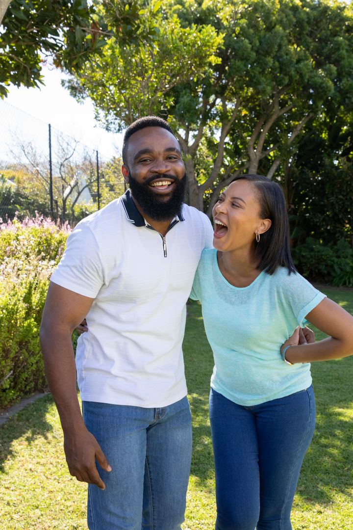 Happy Couple Laughing Together in Sunlit Garden