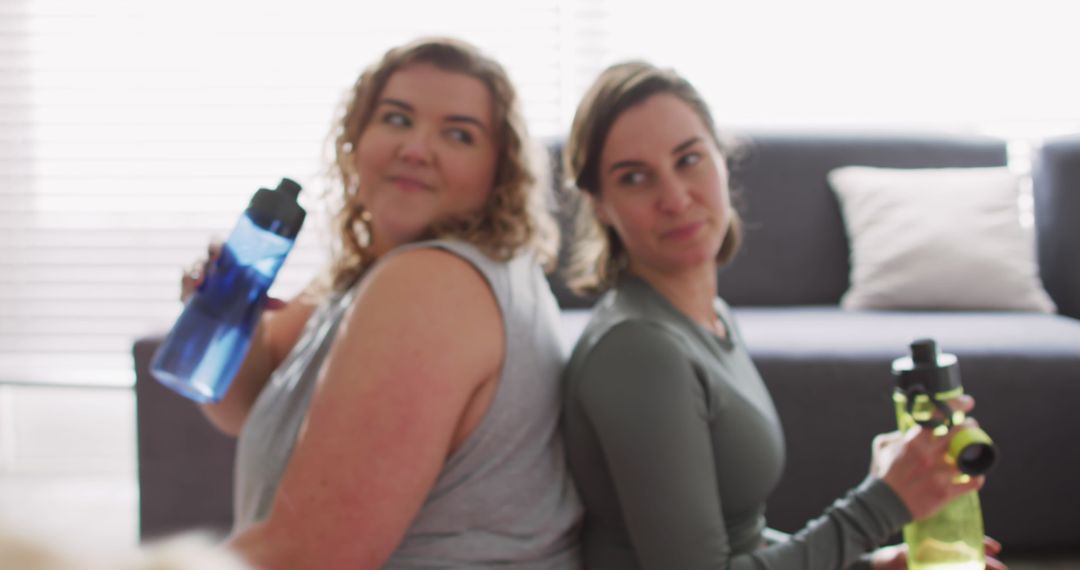 Two Women Enjoying Refreshing Break During Workout