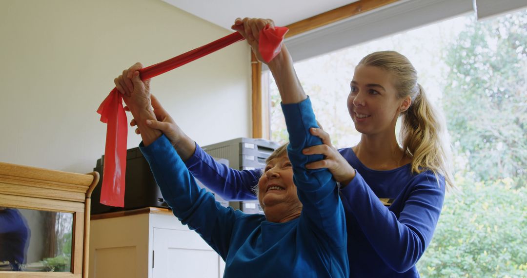 Female Therapist Guiding Elderly Woman's Rehabilitation Exercise with Elastic Band - Free Images, Stock Photos and Pictures on Pikwizard.com