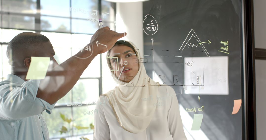 Diverse Team Brainstorming Innovative Business Strategy on Glass Board