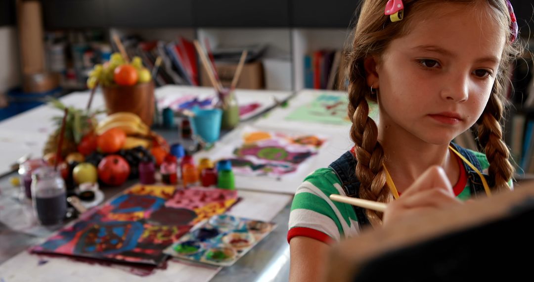 Young Girl Focused on Painting in Art Class