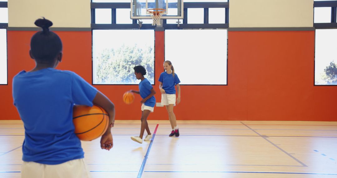 Female Athletes Practicing Basketball in Gym Setting