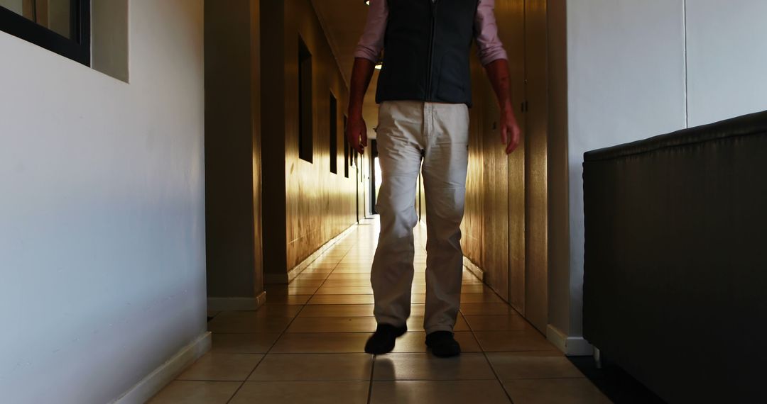 Man Walking Through Hallway towards Bright Light - Free Images, Stock Photos and Pictures on Pikwizard.com