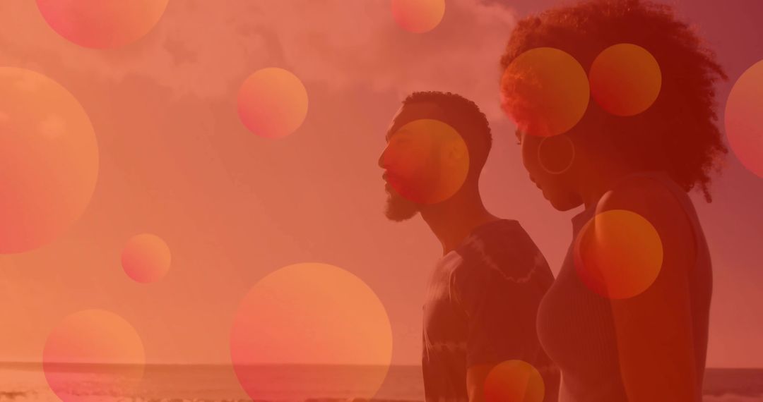 Silhouetted Couple Walking Along Beach with Warm Bokeh