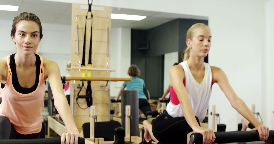 Young Women Exercising on Pilates Reformers in Fitness Studio - Free Images, Stock Photos and Pictures on Pikwizard.com