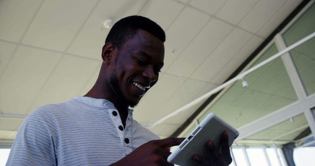 Smiling African American Man Using Tablet Indoor - Free Images, Stock Photos and Pictures on Pikwizard.com