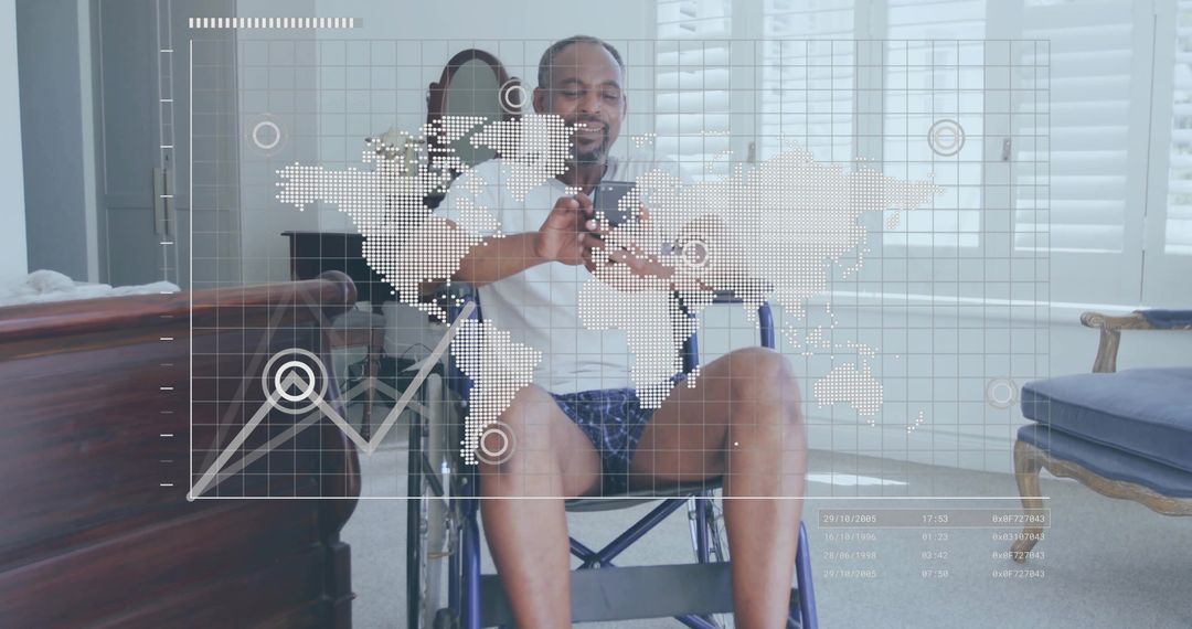 Smiling mature man in wheelchair holding smartphone with world map and data graph overlay