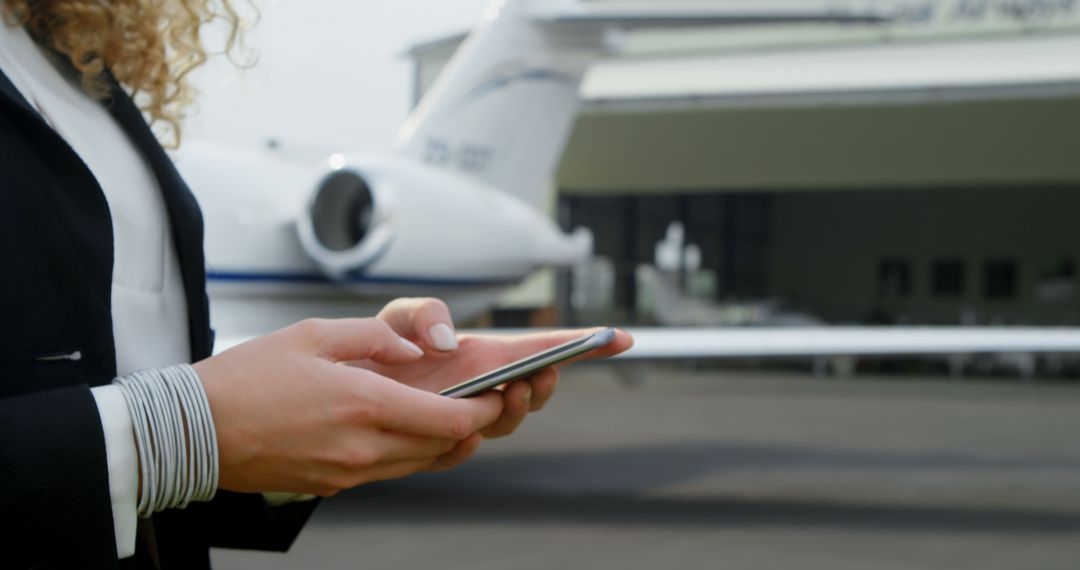 Professional Pilot Using Smartphone at Airport for Flight Logistics Coordination