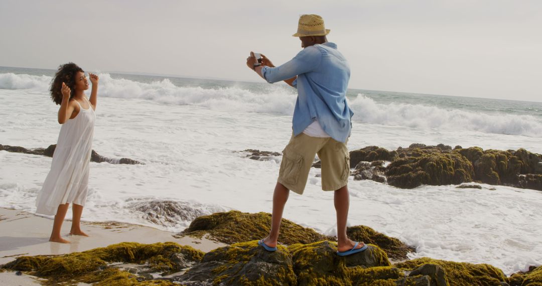 Man Photographing Woman Dancing on Scenic Beach in Summer