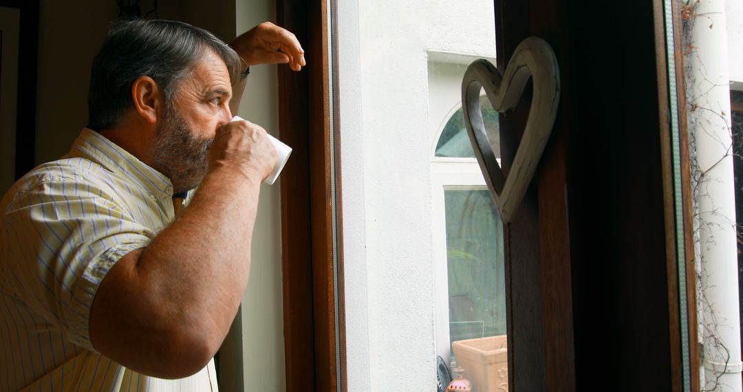 Mature Man Drinking Coffee While Gazing Out Window at Home - Free Images, Stock Photos and Pictures on Pikwizard.com