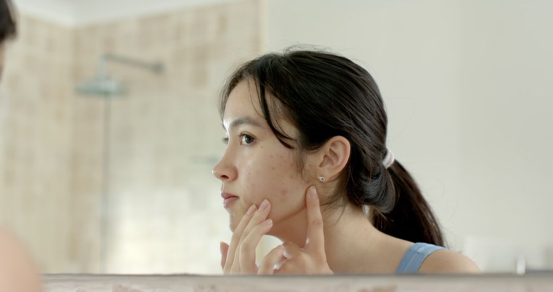 Woman Focusing on Skincare Routine in Bathroom Setting