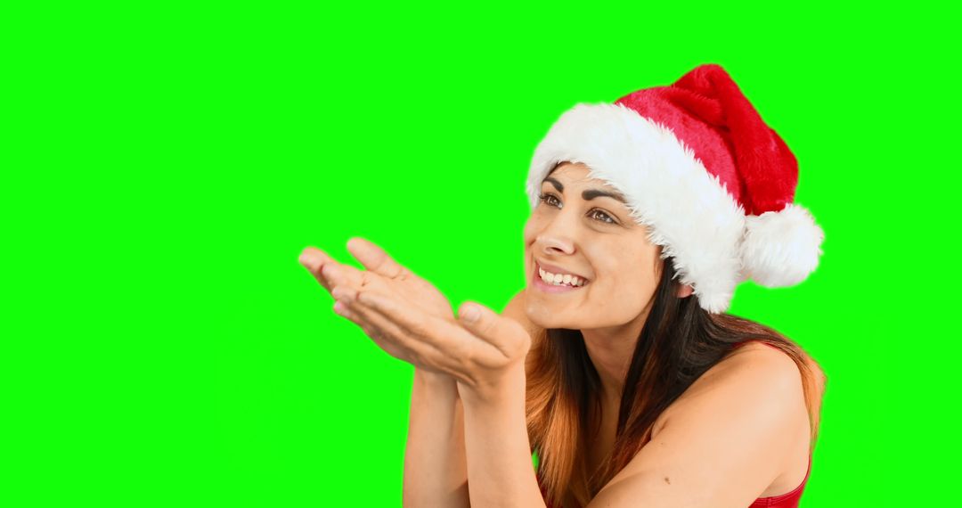 Smiling Woman in Santa Hat Blowing Kiss on Green Background - Free Images, Stock Photos and Pictures on Pikwizard.com