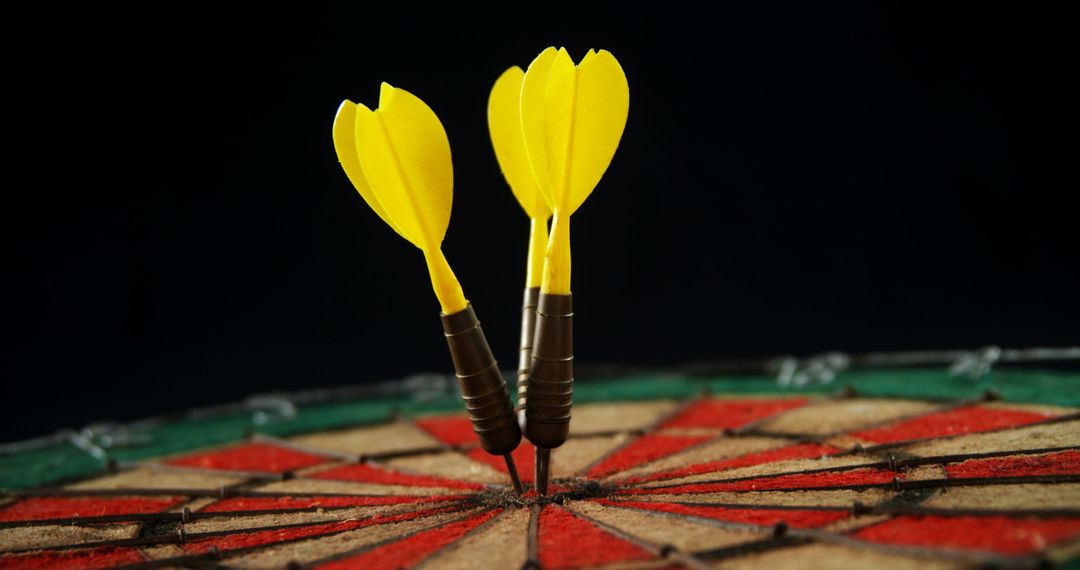 Two Yellow Darts Hitting Bullseye on Dartboard Over Dark Background - Free Images, Stock Photos and Pictures on Pikwizard.com