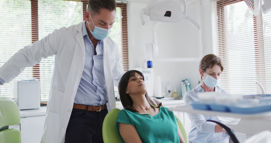 Dentist Examining Female Patient While Assistant Prepares Tools - Free Images, Stock Photos and Pictures on Pikwizard.com