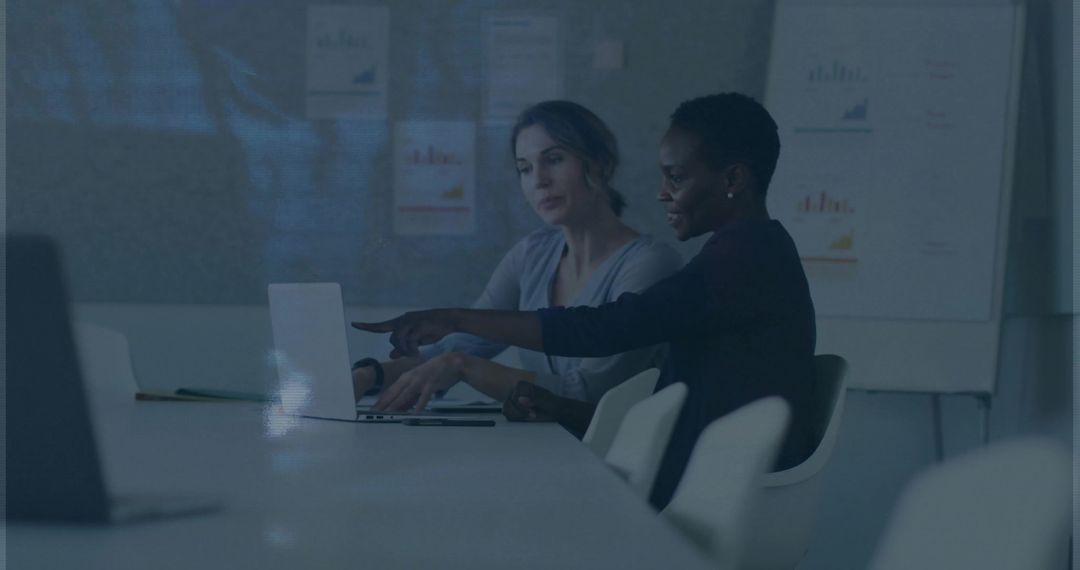 Women Collaborating in Modern Office Brainsorming Over Laptop with Charts