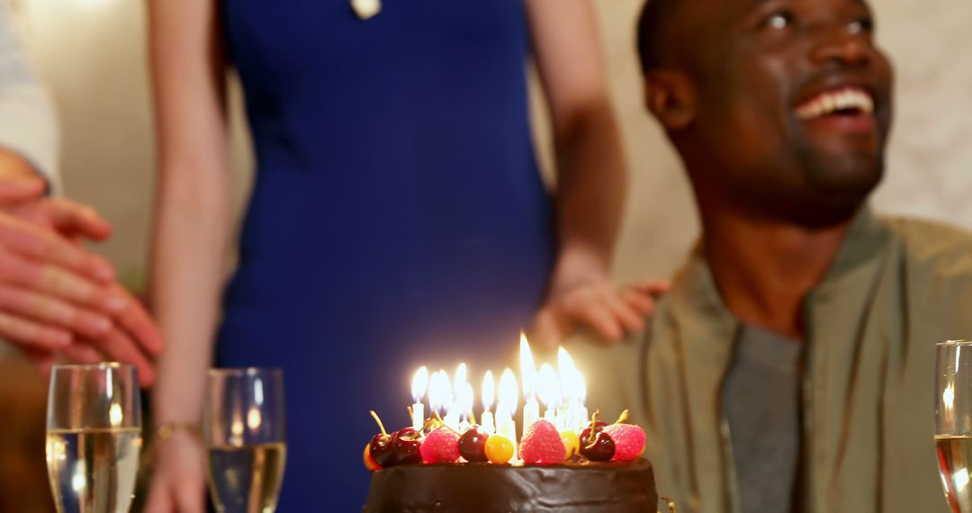 African American man enjoying a birthday celebration with a cake on the table, with copy space - Free Images, Stock Photos and Pictures on Pikwizard.com