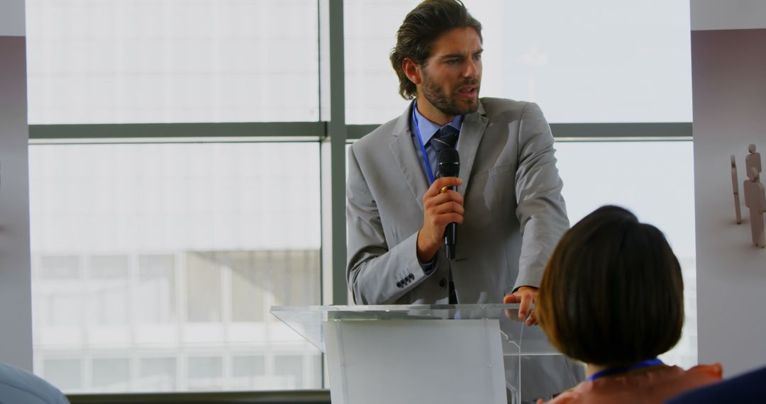 Businessman Speaking at Podium During Seminar Presentation
